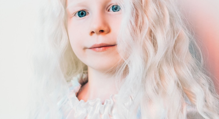 bambina albina con lunghi capelli bianchi, camicetta bianca e sfondo bianco