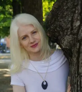 ragazza albina dietro un albero