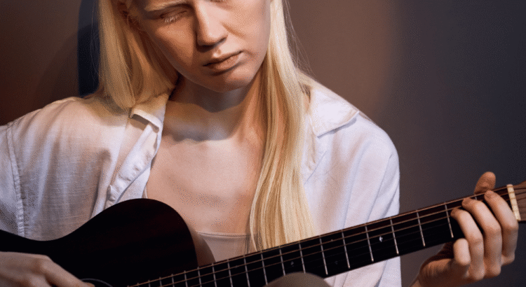 ragazza albina suona la chitarra